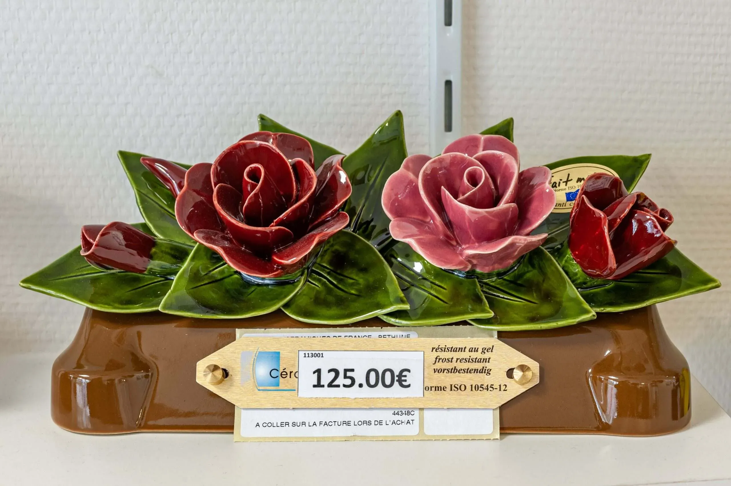 Décoration funéraire en céramique avec roses en relief.