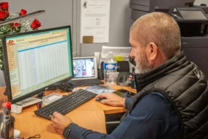 Conseiller funéraire travaillant sur ordinateur dans un bureau d'accueil.