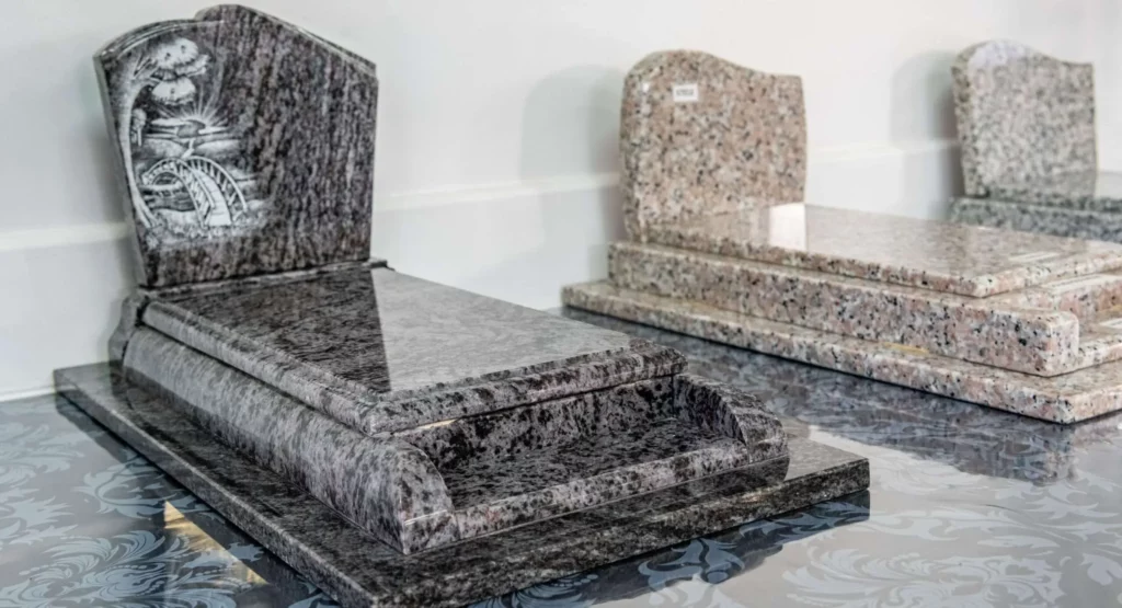 Modèles réduits de monuments funéraires en granit exposés.